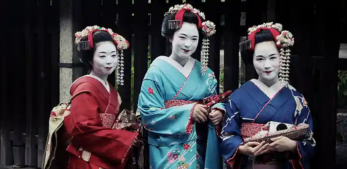 Three Geisha women posiing in Gion, Kyoto